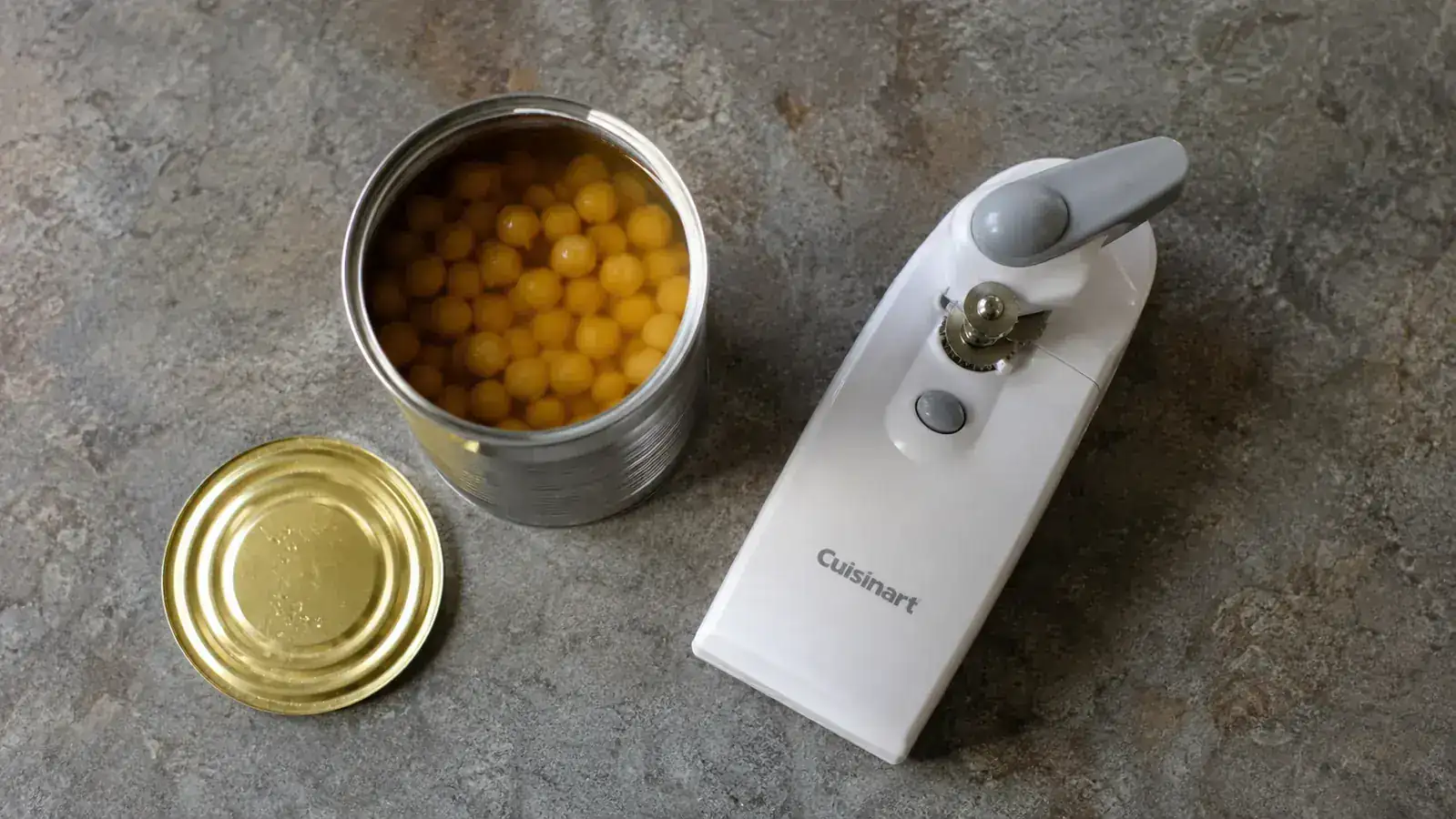 Smooth-edge lid removed from an open can sitting next to an electric can opener